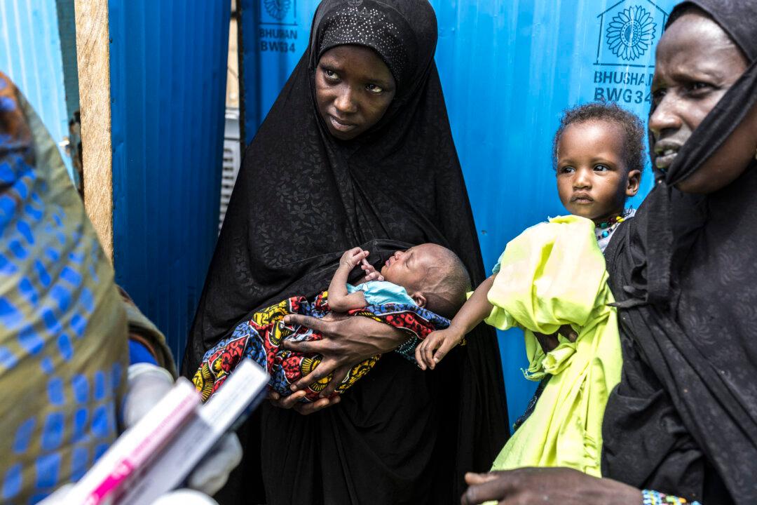 A refugee (C) holds her new born baby as she listens to a health worker at a Doctors Without Borders (MSF) health center in Doueinkara, near the Mauritanian border with Mali, on April 29, 2026. Thousands of people have died in attacks in Mali since the jihadist turmoil erupted and tens of thousands of Malians have sought refuge in neighbouring countries, including Mauritania, in recent years. (Patrick Meinhardt/ AFP via Getty Images)