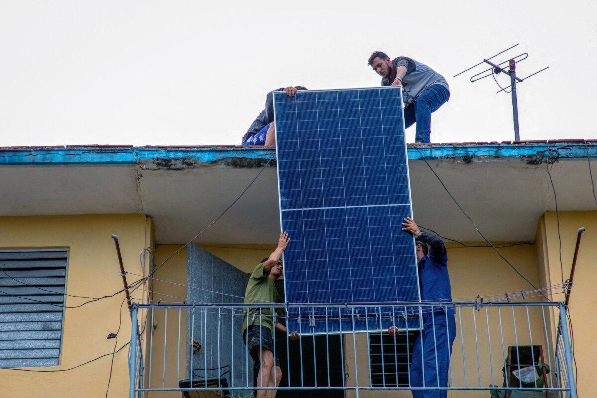 Solar panel specialists install solar panels on the rooftop of a multifamily building in Matanzas, Cuba, on April 13, 2026. (AFP via Getty Images)