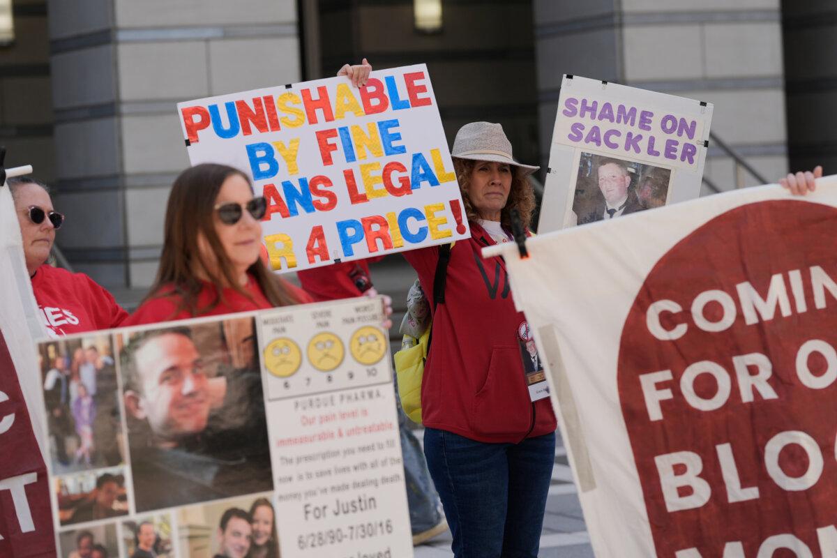 People rally outside a courthouse while a hearing for Purdue Pharma takes place inside in Newark, N.J., on April 21, 2026. (Seth Wenig/AP Photo)