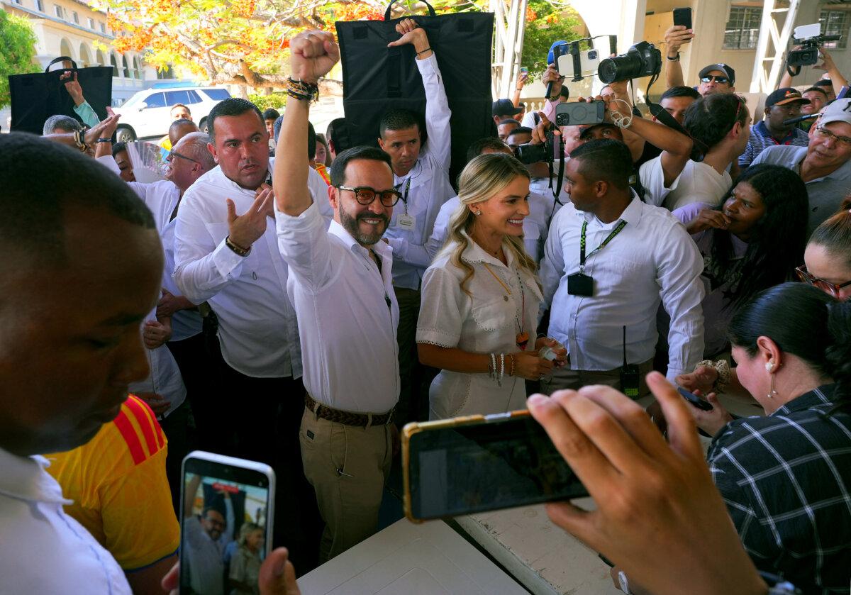 Colombia's presidential candidate Abelardo de la Espriella, of the Salvadores de la Patria movement, greets supporters accompanied by his wife Ana Lucia Pineda before voting at a polling station during the presidential election in Barranquilla, Colombia, on May 31, 2026. (Vanessa Romero/AFP via Getty Images)