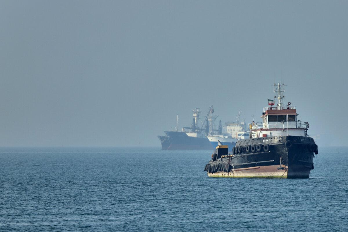An Iranian tugboat floats in the foreground as cargo ships sit at anchor in the Strait of Hormuz off Bandar Abbas, Iran, on May 4, 2026. (Amirhosein Khorgooi/ISNA via AP)