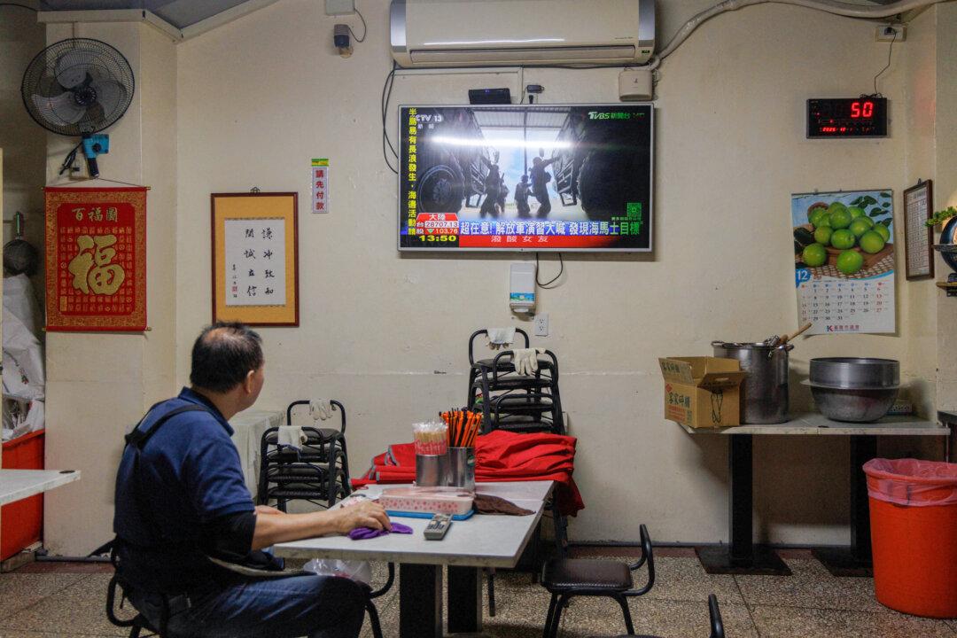 A man watches TV news coverage of the Chinese People’s Liberation Army military drills around Taiwan in Keelung, Taiwan, on Dec. 30, 2025. In recent years, the CCP has frequently carried out large-scale military exercises in the Taiwan Strait, while sending military jets and warships to the airspace and water near Taiwan on an almost daily basis. (Cheng Yu-chen/AFP via Getty Images)