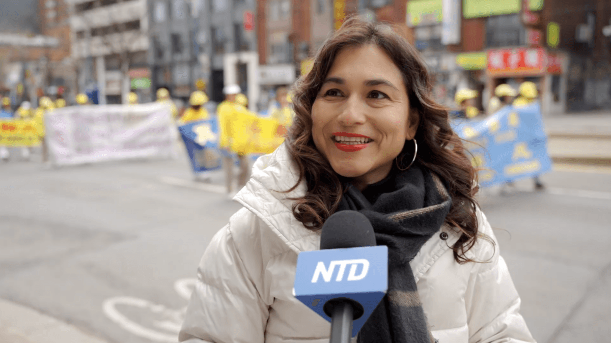 Sandra Gutierrez, a financial specialist, speaks to NTD as she watches the World Falun Dafa Day parade in downtown Toronto on May 3, 2026. (NTD)