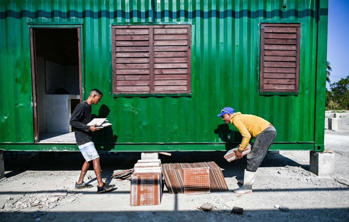 Workers carry construction materials outside a housing unit made from a converted shipping container in Havana on May 7, 2026. (Yamil Lage/AFP via Getty Images)