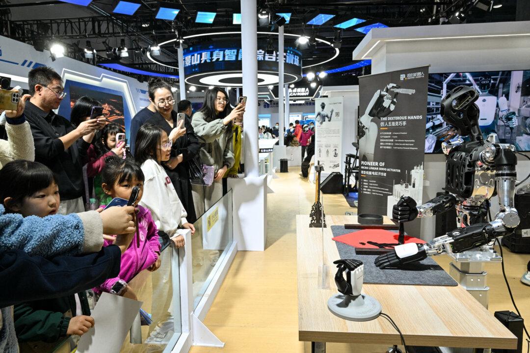 Visitors take pictures of a robot from Yinshi company during the Beijing Sci-Fi Carnival in Beijing on March 28, 2026. By losing access to cheap Iranian oil, China’s artificial intelligence development and overall economic outlook will be weakened by higher energy costs, Yeh Yao-yuan said. (Adek Berry/AFP via Getty Images)