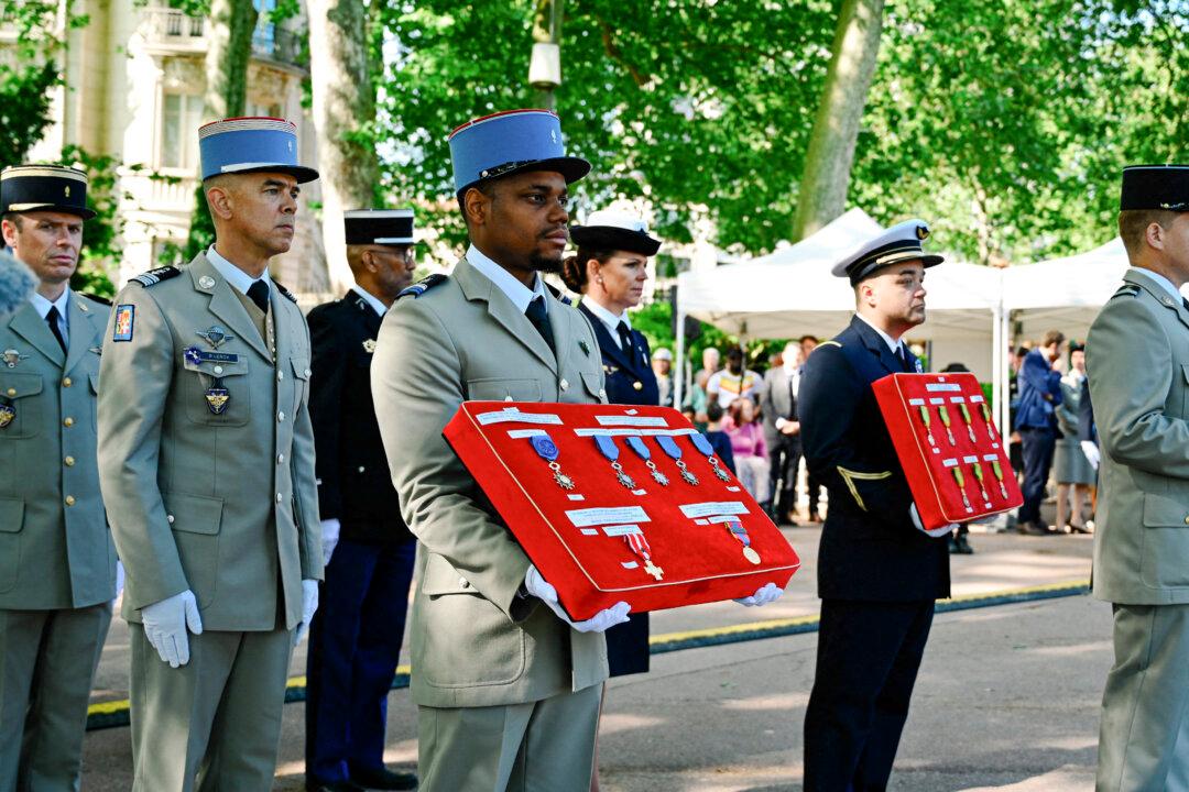French army soldiers carry cushions with military medals attached to them during the national ceremony marking the anniversary of the victory of May 8 1945 and the liberation of France at the Golden Head Park in Lyon in France on May 8 2026. (Photo by Matthieu Delaty / Hans Lucas / AFP via Getty Images)