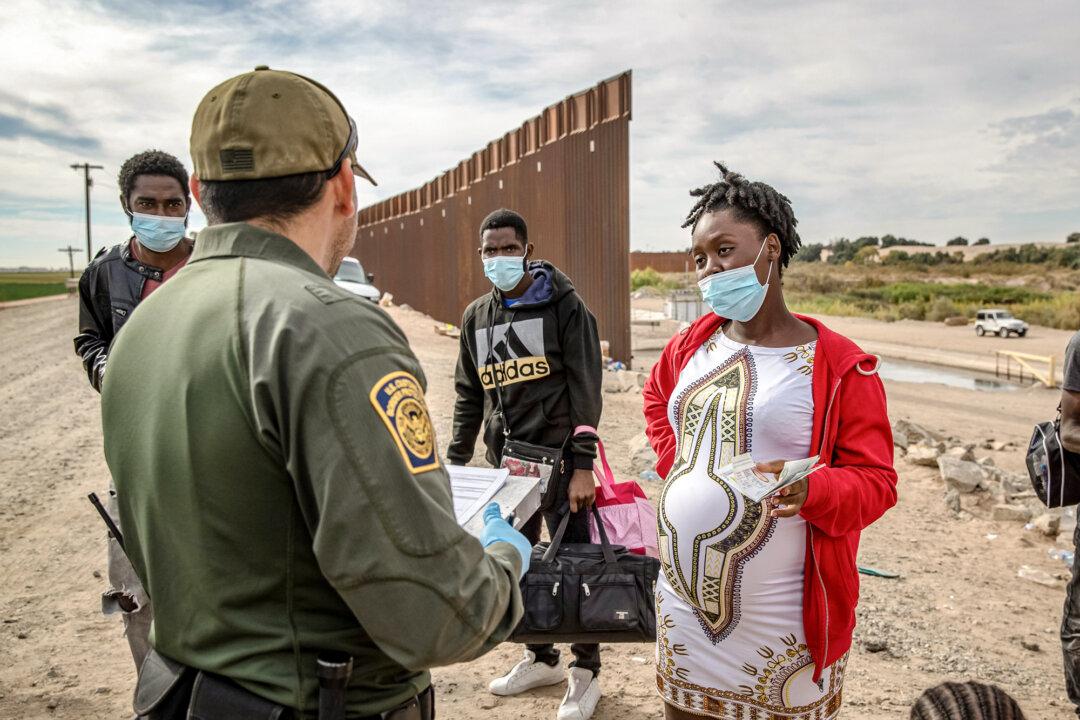 Migrants, including a pregnant Haitian woman seeking to give birth in the United States, are apprehended by a U.S. Border Patrol agent in Yuma, Ariz., on Dec. 7, 2021. The Supreme Court is expected to rule on the constitutionality of a Trump executive order aimed at restricting birthright citizenship before the end of June. (John Moore/Getty Images)