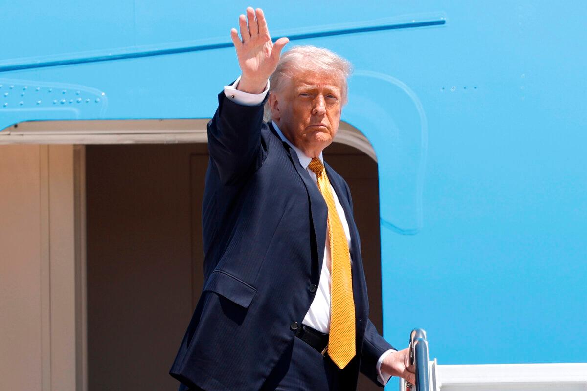 U.S. President Donald Trump waves from the stairs of Air Force One as he boards upon his arrival at Joint Base Andrews, Md., on May 12, 2026. (Luis M. Alvarez/AP Photo)