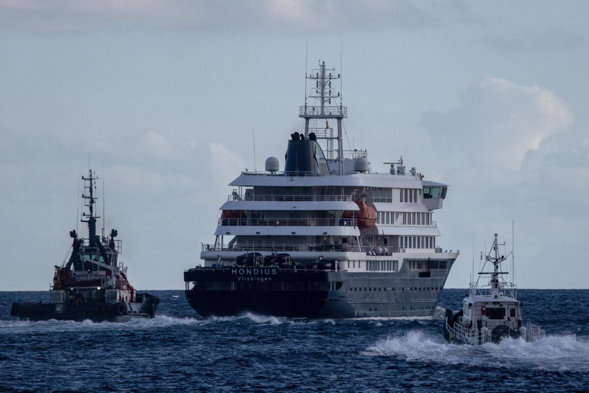 Port vessels accompany the MV Hondius as it departs the Granadilla Port after all passengers were evacuated in Tenerife, part of the Canary Islands, Spain, on May 11, 2026. (Chris McGrath/Getty Images)