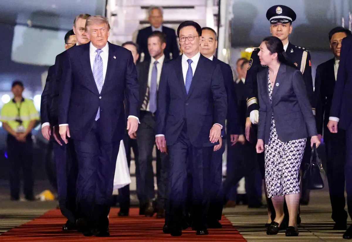 China's Han Zheng (C) escorts U.S. President Donald Trump (L) as he arrives at Beijing Capital International Airport on May 13, 2026, in Beijing. (Alex Wong/Getty Images)