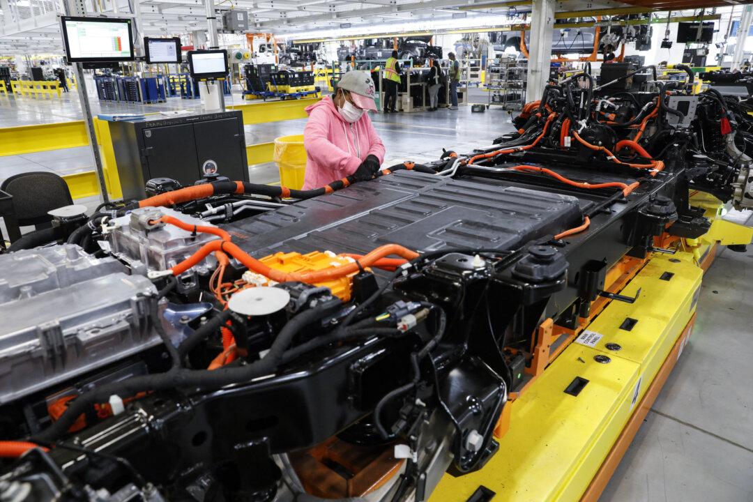 A worker checks battery cables for Ford Motor Co.’s F-150 Lightning trucks at the Rouge Electric Vehicle Center in Dearborn, Mich., on Sept. 20, 2022. As half a million tons of electric vehicle batteries reach end-of-life each year, they are increasingly reused to power homes and provide emergency storage. (Jeff Kowalsky/AFP via Getty Images)