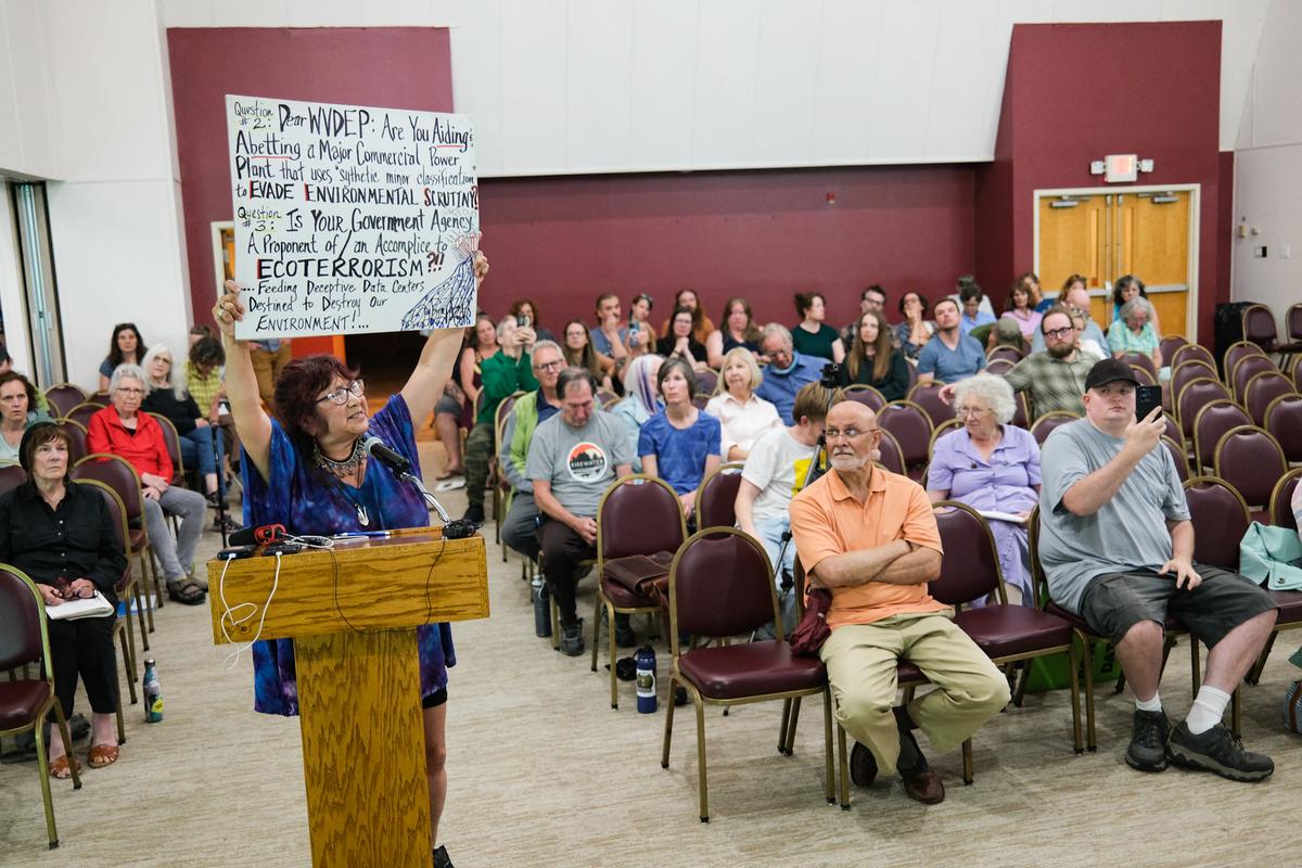 2025年6月30日,在西弗吉尼亞州迦南谷(Canaan Valley)舉行的一次公眾會議上,一位當地居民舉著標語牌。數據中心巨大的電力和用水量仍然是居民在考慮新項目時最關心的問題。(Ulysse Bellier/AFP via Getty Images)