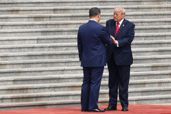 U.S. President Donald Trump (R) is greeted by Chinese leader Xi Jinping during a welcome ceremony in Beijing on May 14, 2026. (Alex Wong/Getty Images)