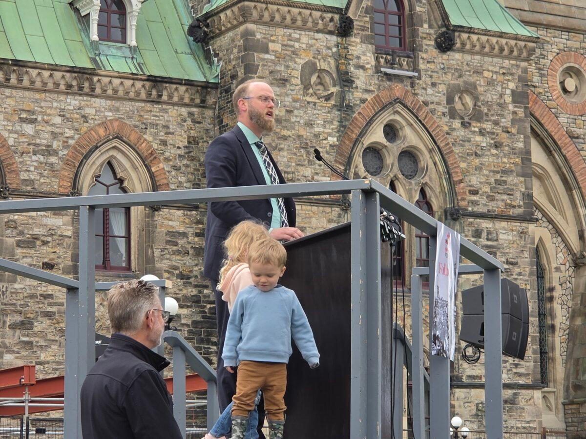 Conservative MP Arnold Viersen addresses a crowd of pro-life advocates on May 14, 2026, while two of his children stand on stage. (Matthew Horwood/The Epoch Times)