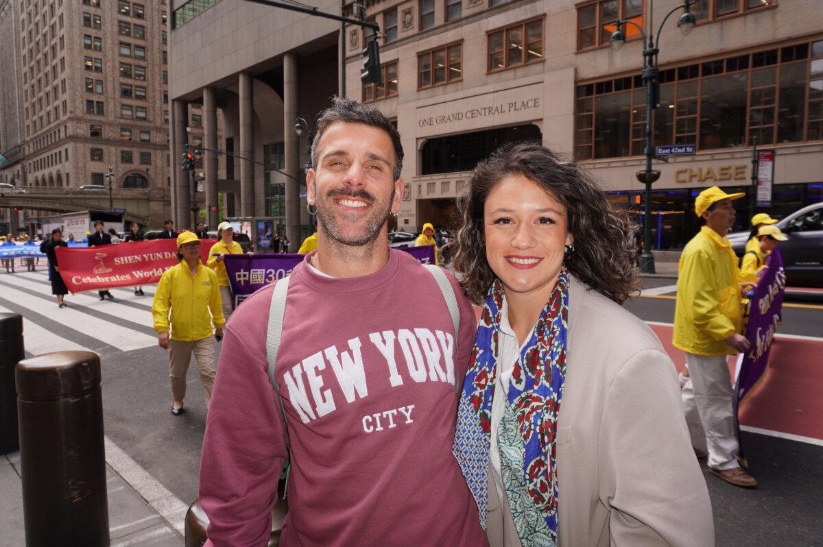 João Pedro, a gym owner from Spain, and his girlfriend Patrick Blanco, who were visiting New York, watched the Falun Dafa Day parade in Midtown Manhattan on May 13, 2026. (Yu Lili/The Epoch Times)