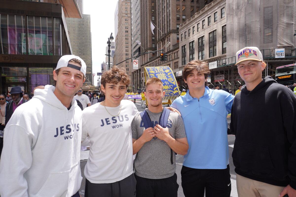 Young CEO Charles Johnson from Indianapolis (L) brought his colleagues to watch the Falun Dafa Day parade in Midtown Manhattan on May 13, 2026. He said he plans to try practicing Falun Gong after returning home. (Yu Lili/The Epoch Times)
