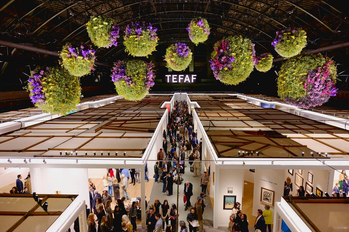 Flowers hang above the gallery booths inside the Wade Thompson Drill Hall during the 2026 fair. (Courtesy of TEFAF New York)