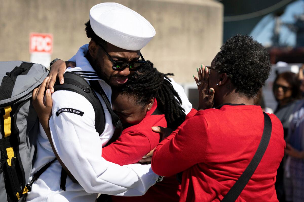 Roderick Watkins embraces his sister, as his mother looks on, after disembarking the aircraft carrier USS Gerald R. Ford at Naval Station in Norfolk, Va., on May 16, 2026. (Mike Kropf/Getty Images)