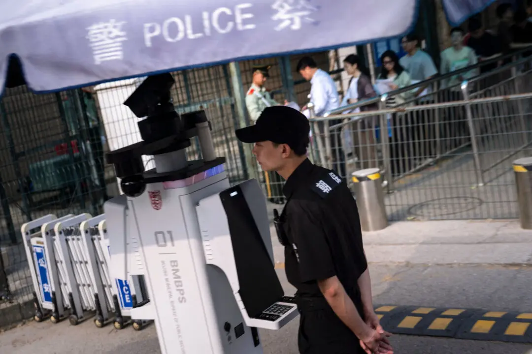 A police officer stands at a corner as people wait in a consular service line outside the U.S. Embassy in Beijing on May 14, 2026. (Brendan Smialowski/AFP via Getty Images)