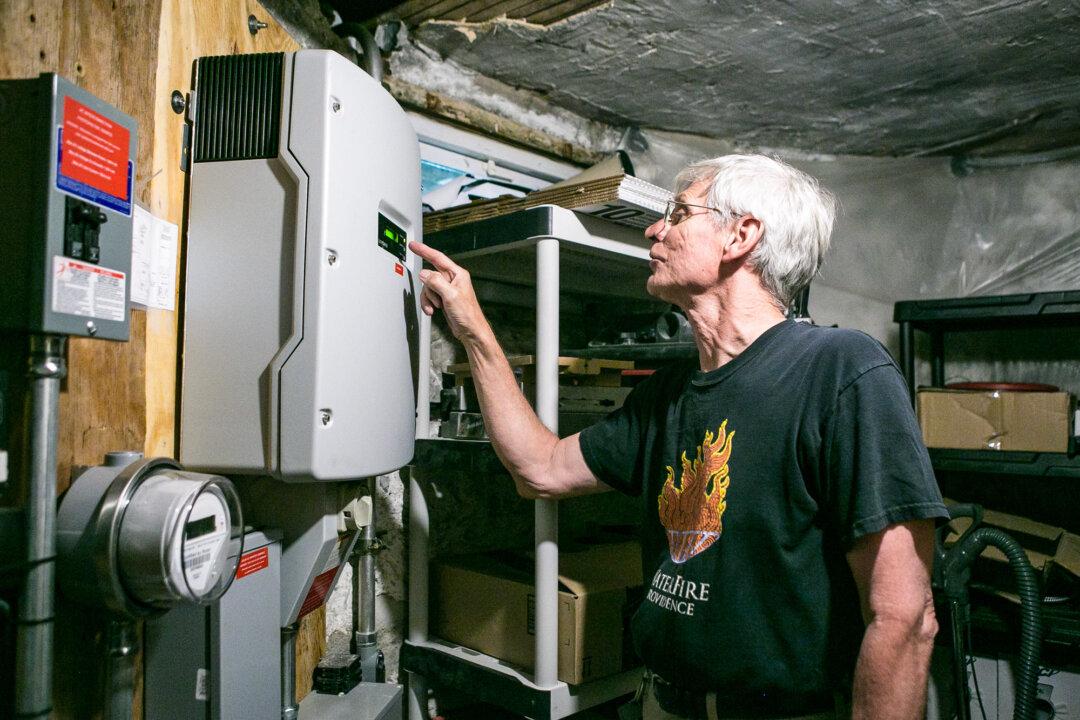 Michael O’Malley shows a smart meter monitoring electricity flow to and from his home in Brooklyn, N.Y., on Aug. 3, 2015. Professor Charles Bullock III from the University of Georgia said electricity bills are ripe targets for Democrats looking to unseat Republicans, who voters will perceive as responsible–fairly or not–for rising rates. (Samira Bouaou/The Epoch Times)