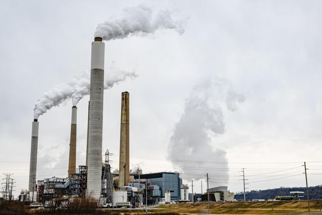 Flue-gas stacks of a coal-fired power plant are seen from the Valley Village neighborhood in Louisville, Ky., on Feb. 14, 2026. The Energy Information Administration documented in late 2024 that 173 of the 401 coal-fired power plants in 33 states were set to close by 2030. (Jon Cherry/Getty Images)