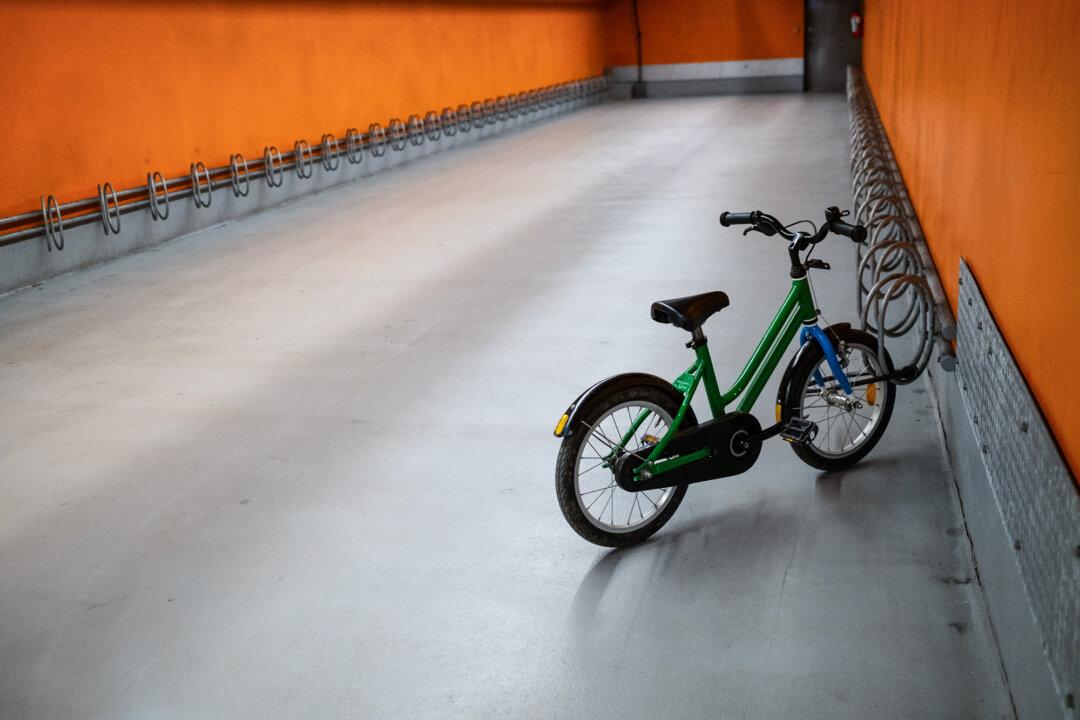 A child’s bicycle sits on a bike rack in a train station in Copenhagen, Denmark, on April 24, 2026. (John Fredricks/The Epoch Times)