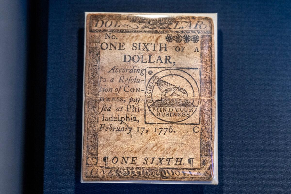 A Continental one-sixth dollar bill on display at the Federal Reserve Bank of Philadelphia’s newly redesigned “Money in Motion” exhibit Thursday, May 7, 2026. This bill was issued in Philadelphia by the Continental Congress on Feb. 17, 1776, to fund the Revolutionary War. Designed by Benjamin Franklin, the note features a “Fugio" motif and the phrase "Mind Your Business.” Counterfeiting was rampant and far too many of the bills were printed so by 1779, Continental dollars were nearly worthless. (Tom Gralish/The Philadelphia Inquirer/TNS)