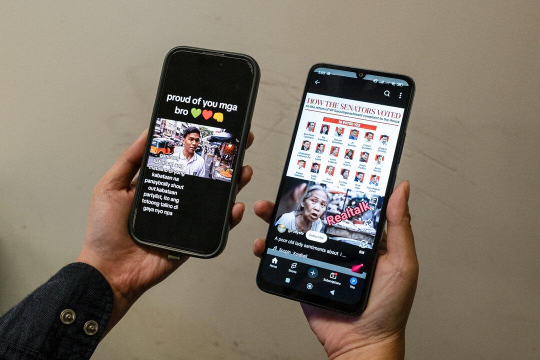 This photo illustration shows a person holding two mobile phones displaying viral AI-generated videos of students and an elderly woman sharing views on the impeachment of Philippine Vice President Sara Duterte in Hong Kong on June 20, 2025. Days after the Philippine Senate declined to launch the impeachment trial, the two videos arguing for and against the move went viral. (Yan Zhao/AFP via Getty Images)
