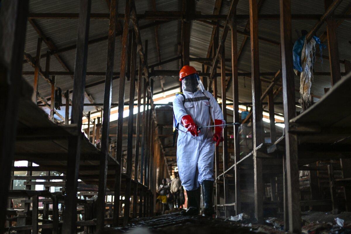 A sanitation worker from the Bunia city government sprays chlorine to disinfect the central market, as Ituri Province continues to combat an Ebola outbreak, in Bunia, Congo, on May 23, 2026. (Moses Sawasawa/AP Photo)