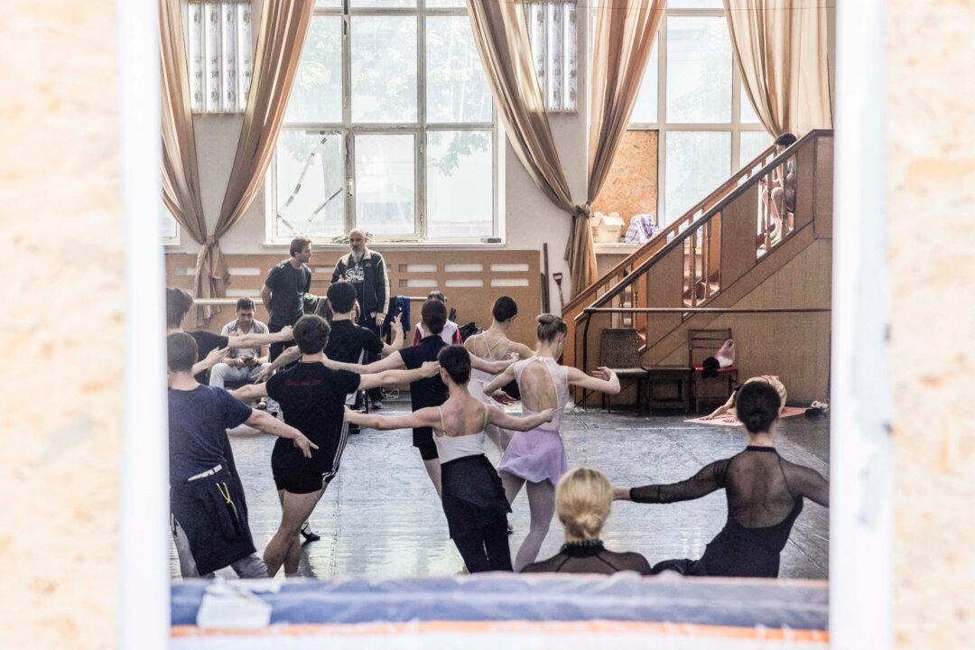 Dancers rehearse the two-act ballet "Giselle" through a broken window covered with plywood at the Kyiv Municipal Academic Opera and Ballet Theater, which has been damaged on May 24 following Russian strikes, on May 27, 2026, amid the Russian invasion of Ukraine. Russia pounded Kyiv on May 24 with a massive missile and drone attack that killed four people. The roof of the Kyiv Opera was damaged and 72 windows were shattered in the attack. Despite the damage, artists returned to work, and the opera resumed scheduled performances the following day. (Photo by Tetiana DZHAFAROVA / AFP via Getty Images)
