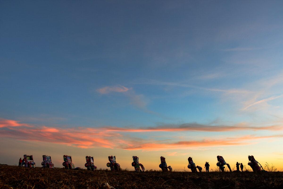 Visitors to Cadillac Ranch art installation in Amarillo, Texas, are allowed to spray the 10 Cadillacs half-buried in the ground there, seen on Nov. 11, 2025. (Christopher Reynolds/Los Angeles Times/TNS)