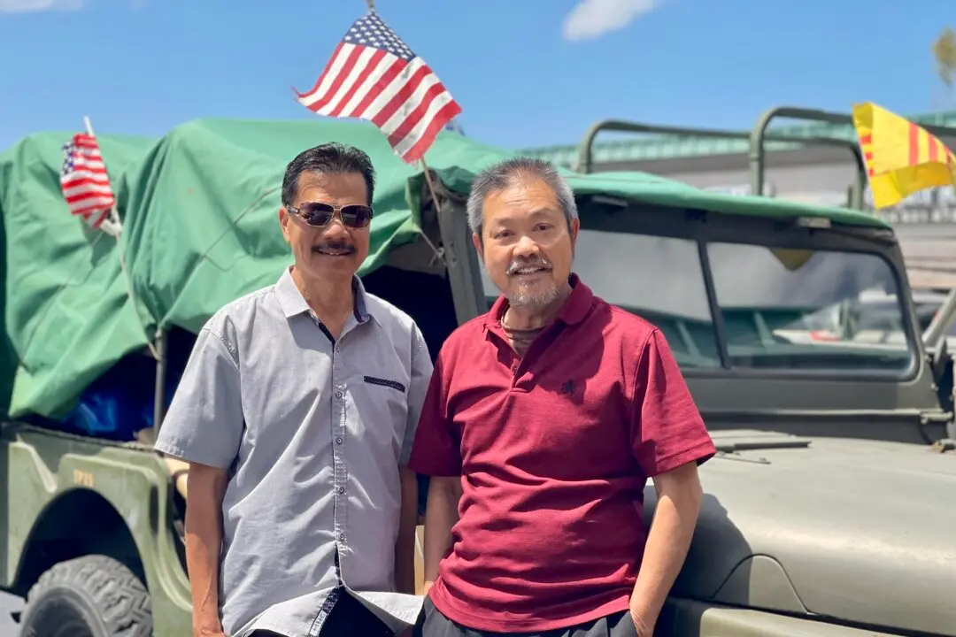 Sy Nguyen (L) and David Pham stand next to an antique de-comissioned U.S. Army Jeep flying American and South Vietnamese flags near Pham's Little Saigon business in Westminster, Calif., on May 27, 2026. Pham told The Epoch Times his vote would go to a Republican, but he hadn’t yet decided which one. (Beige Luciano-Adams/The Epoch Times)