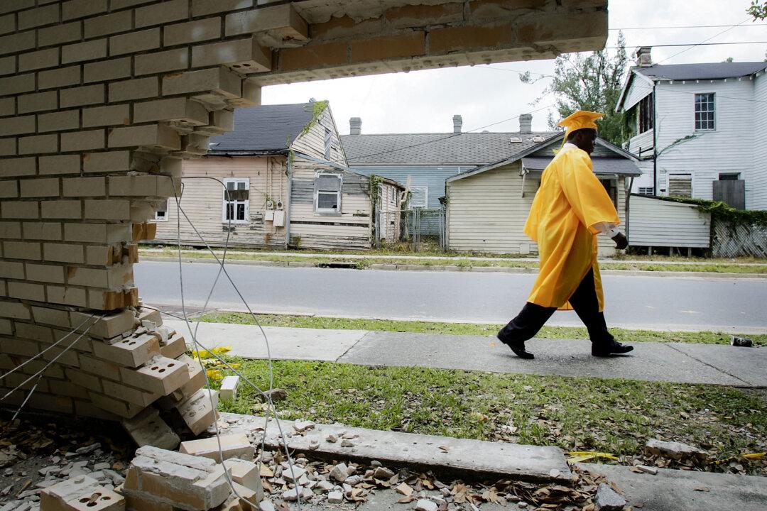 James Holloway, 20, a member of John McDonogh Senior High School’s first graduating class since Hurricane Katrina, walks past a damaged wall on his way to his commencement in New Orleans on June 8, 2007. (Mario Tama/Getty Images)