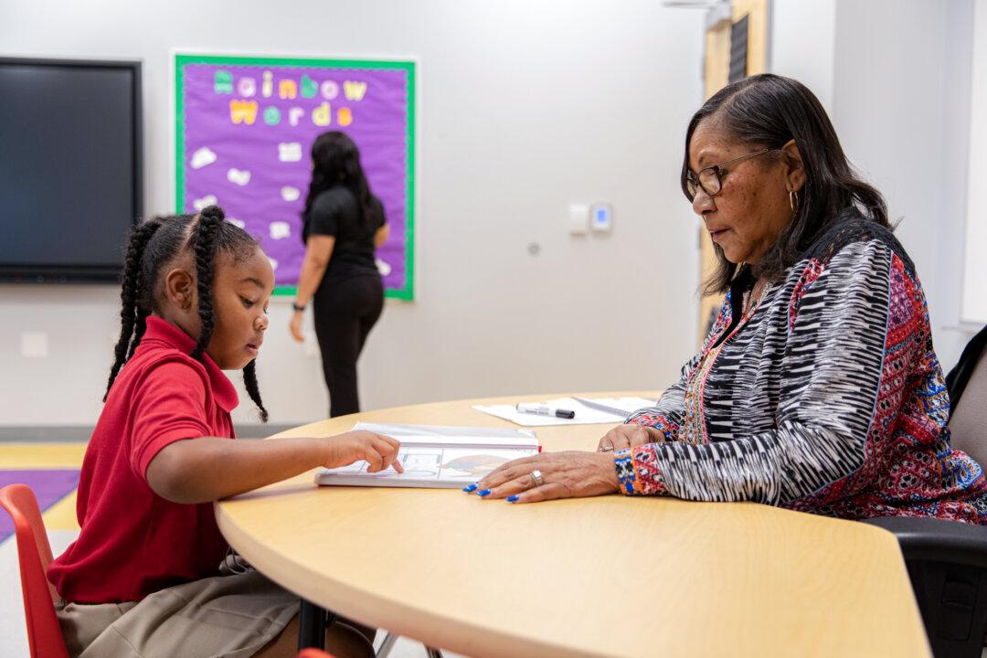 A student reviews schoolwork with a teacher at a Louisiana charter school in this file image. On average, charter schools provide 16 more days of reading instruction and six more days of math instruction per year than traditional public schools. (Courtesy of the Louisiana Association of Public Charter Schools)