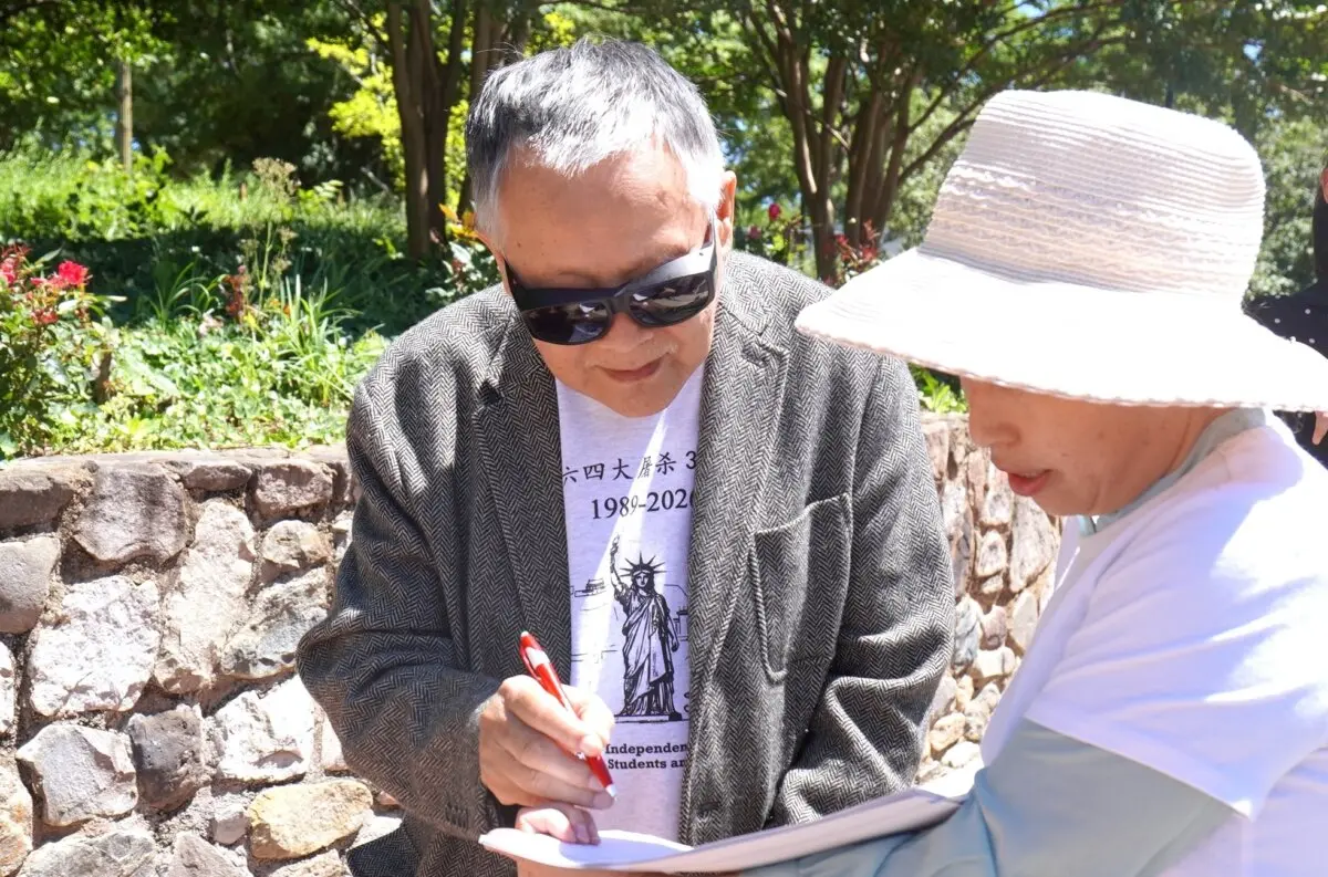 Wei Jingsheng, a prominent Chinese human rights activist, signs a petition in support of the Falun Gong and Victims of Forced Organ Harvesting Protection Act, which aims to sanction perpetrators of state-sanctioned forced organ harvesting in China, in front of the Chinese Embassy in Washington on May 30, 2026. (Sherry Dong/The Epoch Times)