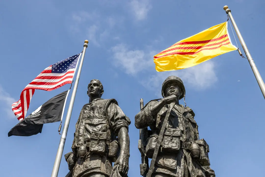 Flags of the United States and the Republic of Vietnam (commonly known as South Vietnam) fly over statues depicting U.S. and South Vietnamese soldiers at a Vietnam War Memorial at Sid Goldstein Freedom Park in Westminster, Calif., on May 22, 2026. Vietnam is now known as the Socialist Republic of Vietnam. (John Fredricks/The Epoch Times)