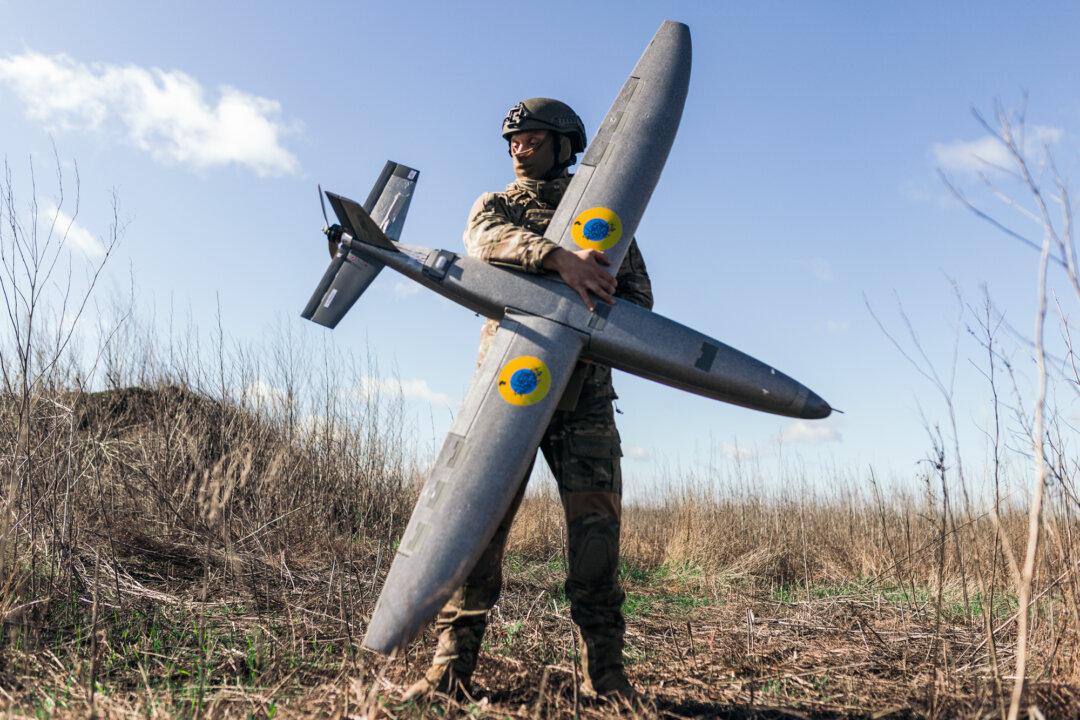 A soldier from the 'Taifun' unmanned aerial vehicle unit holding a new model 'Marsianin' attack drone in the Kharkiv region of Ukraine on April 7, 2026. Ukrainian forces depend on U.S.-made Starlink satellite terminals for battlefield communications, targeting, and drone operations. (Nikoletta Stoyanova/Getty Images)