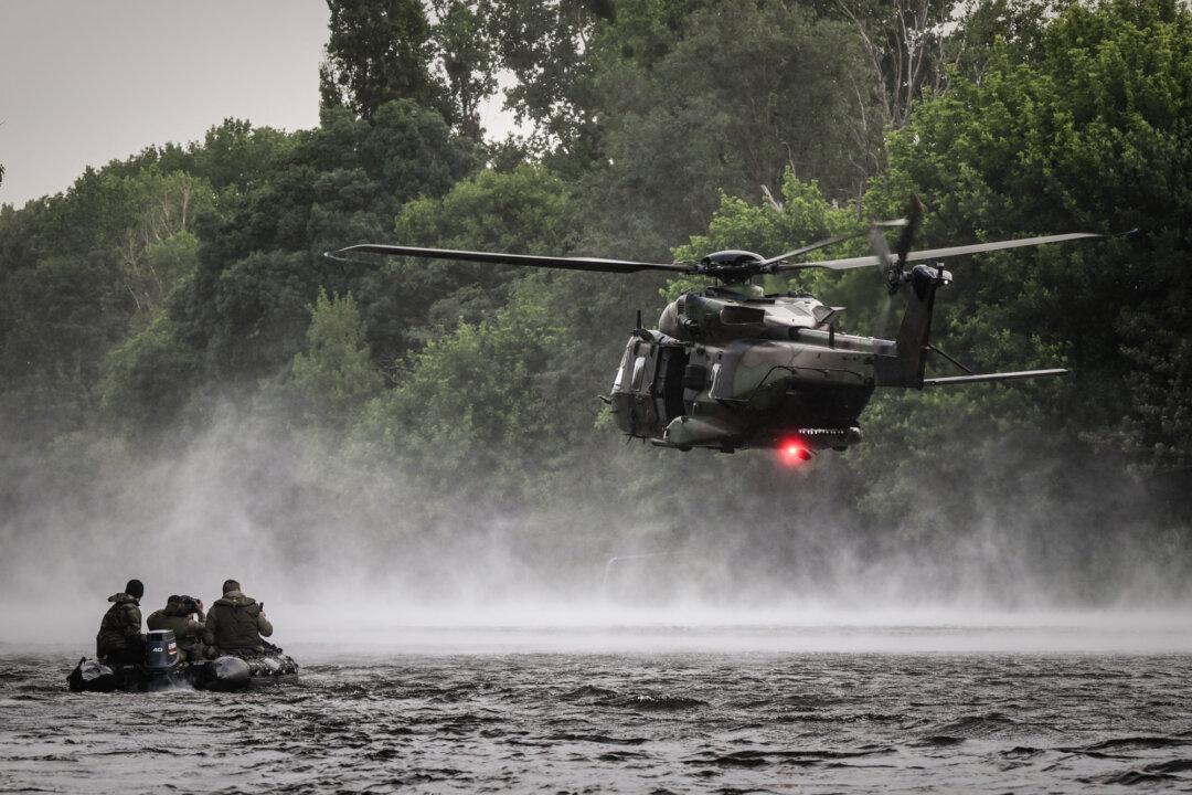French Foreign Legion combat divers from the 2nd Foreign Parachute Regiment wait on an inflatable boat as a NH90 Caïman helicopter hovers above the River Vienne during a water insertion exercise in Ingrandes, France, on May 18, 2026. In most EU member states, parliamentary approval is required for the deployment of armed forces abroad; only France stands out as granting its executive greater flexibility to initiate and sustain military operations with fewer parliamentary constraints. (Philippe Lopez/AFP via Getty Images)