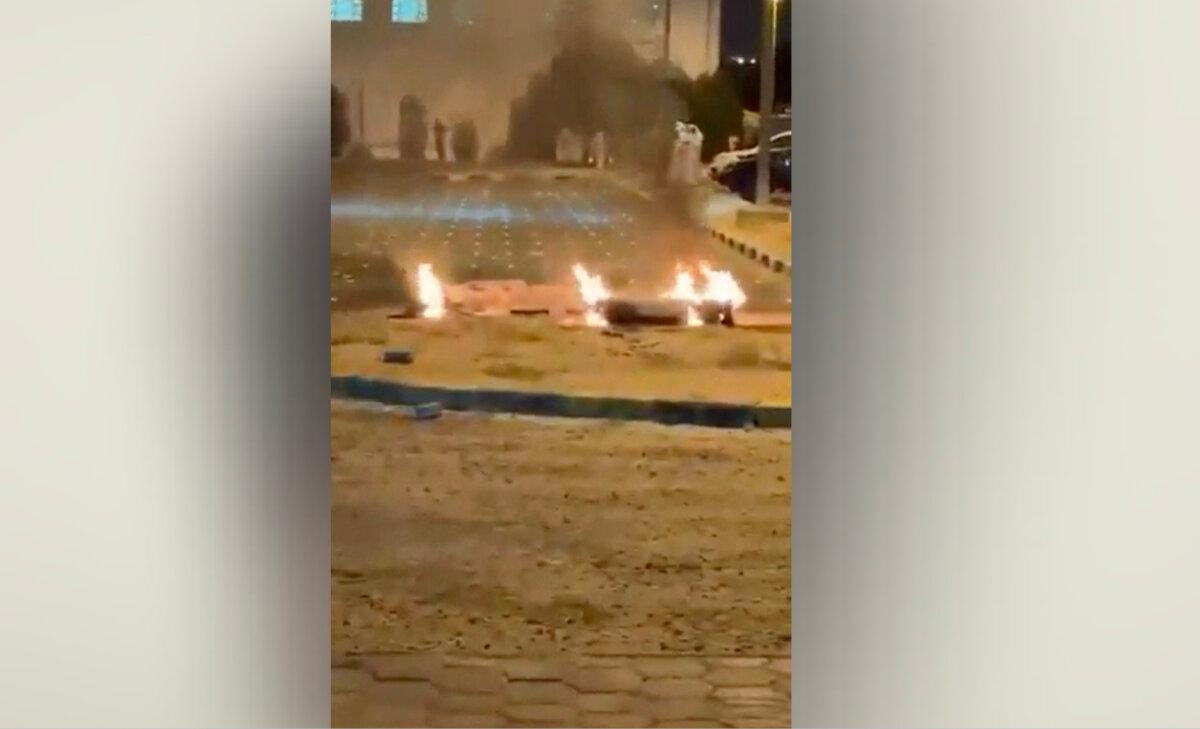 Debris burns on the ground in a parking lot following reports of missile and drone attacks, in Sabah Al Nasser, Kuwait, on June 3, 2026. (Screengrab from social media/via Reuters)