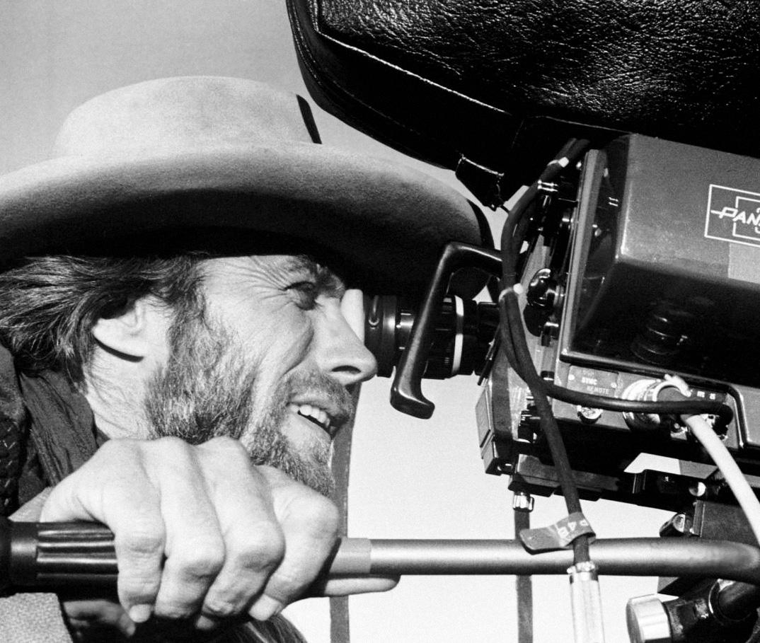 Clint Eastwood looking into the viewfinder of a Panavision camera on the set of the 1976 release, "The Outlaw Josey Wales," his fifth directorial effort. The film was shot in late 1975. (Public Domain)