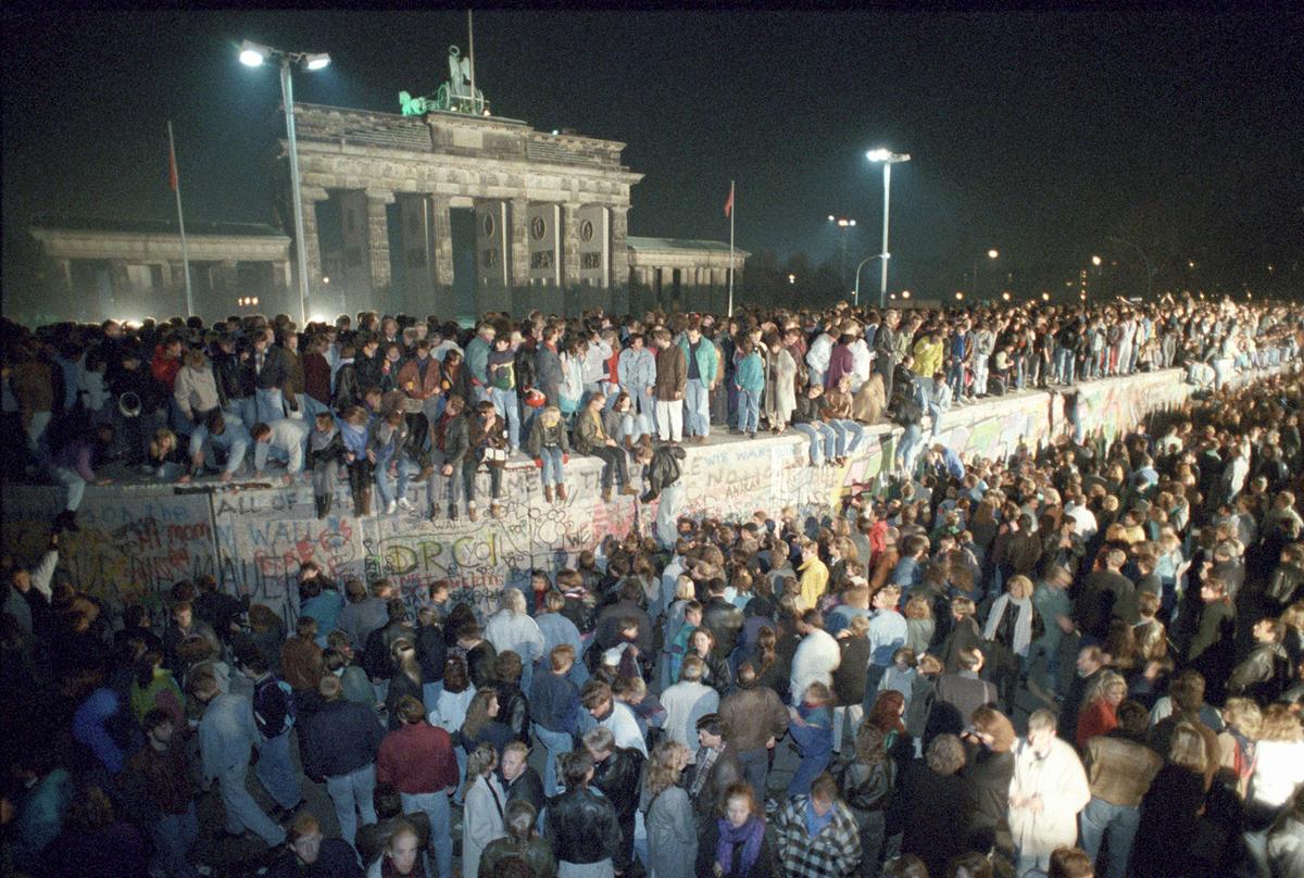 East Berliners standing atop the Berlin Wall near the Brandenburg Gate on Nov. 10, 1989, after the wall fell. (PETER KNEFFEL/dpa/AFP/Getty Images)