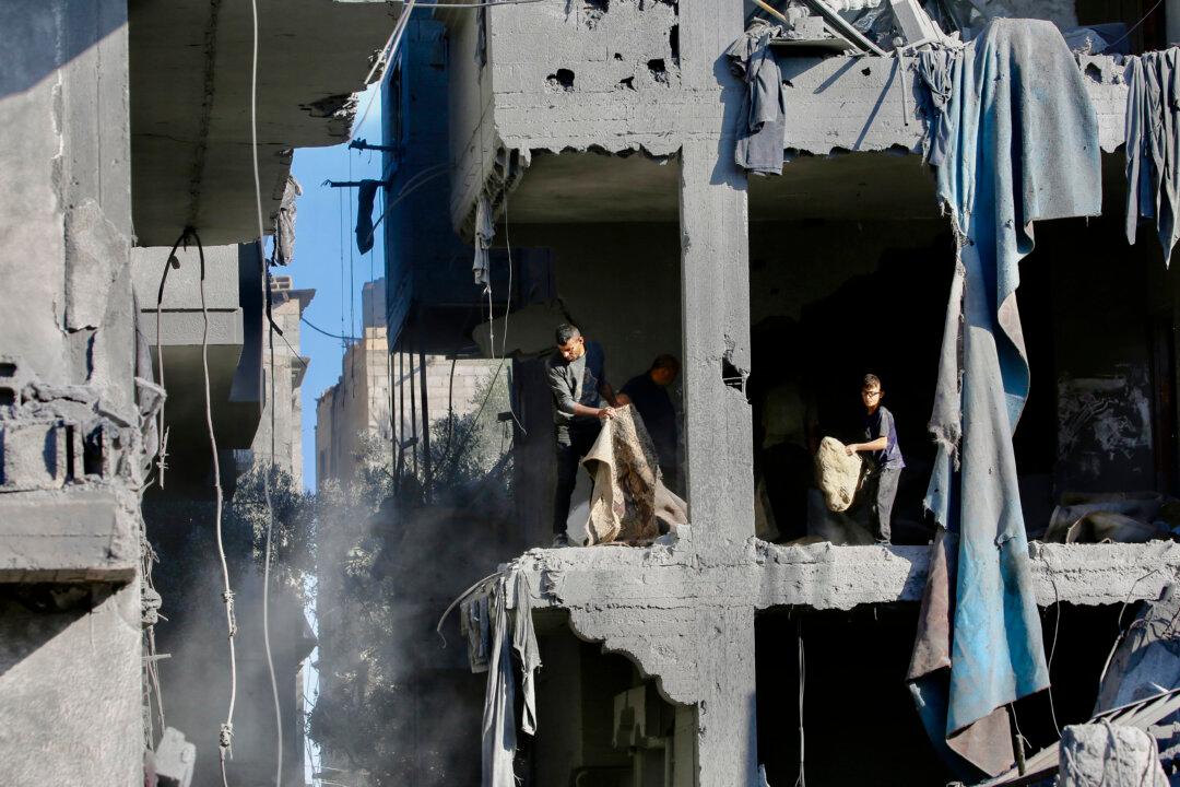 TOPSHOT - Palestinians clear debris at the site of an Israeli strike on a house whose residents were warned to evacuate before the attack, in Zawaida central Gaza Strip on June 5, 2026. Despite a truce technically in effect since October 2025, daily violence has rocked the Gaza Strip, over half of which is under Israeli military control in defiance of the ceasefire's terms. Israel has killed at least 936 people since the ceasefire began, according to Gaza's health ministry, which operates under Hamas authority and whose figures are considered reliable by the UN. (Photo by Eyad Baba / AFP via Getty Images)