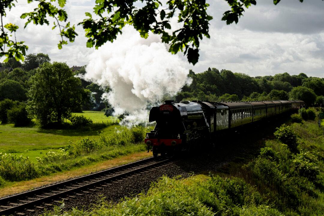 The Flying Scotsman steam locomotive travels along the East Lancashire Railway's line past Burrs Country Park, near Bury in northern England on June 5, 2026. The Flying Scotsman was built in 1923 and holds the record for becoming the first steam locomotive to be officially authenticated at reaching 100 miles per hour on November 30, 1934. Following a 4.2 million GBP refurbishment, the Flying Scotsman returned to the UK's mainline in 2016. The East Lancashire Railway runs a 12 mile heritage railway line between the stations of Heywood and Rawtenstall. (Photo by Oli SCARFF / AFP via Getty Images)