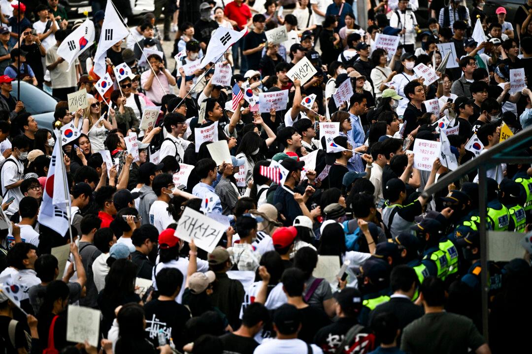 TOPSHOT - Protesters call for the suspension of ballot counting due to a shortage of ballot papers outside a counting station in Seoul on June 5, 2026. South Korean riot police cleared protesters from a Seoul polling station on June 5, after a 35-hour blockade sparked by a ballot shortage during local elections that also led the national election chief to resign. (Photo by Pedro PARDO / AFP via Getty Images)
