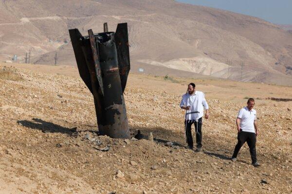 Two men look at a fallen rocket half-buried in the ground, following Iranian and Iran-backed Houthi terror attacks on the outskirts of Jericho, Israel, on June 8, 2026. (Ahmad GHARABLI / AFP via Getty Images)