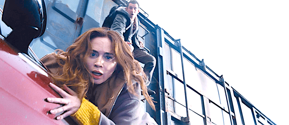 Margaret Fairchild (Emily Blunt) and Daniel Kellner (Josh O'Connor) trying to escape onto a train from their car that's being dragged by the train, in "Disclosure Day." (Universal Pictures)