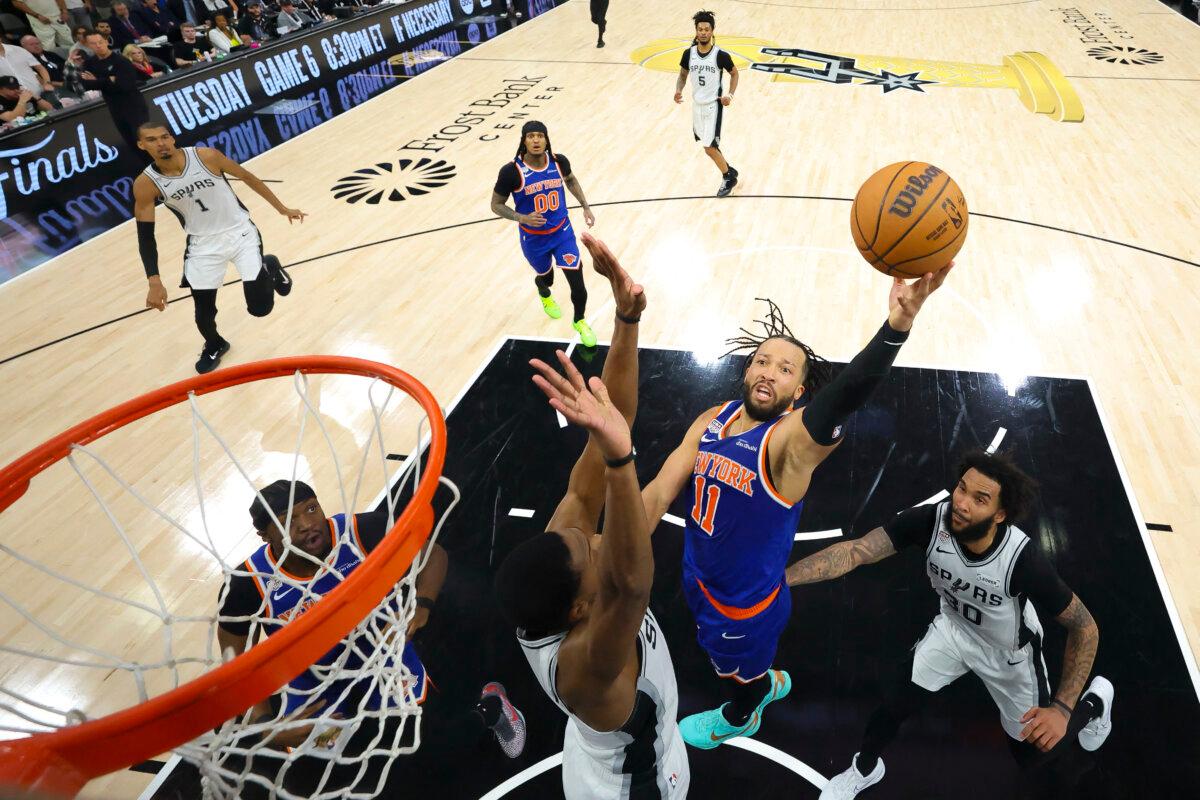 New York Knicks guard Jalen Brunson (11) drives to the basket past San Antonio Spurs forward Julian Champagnie (30) during Game Five of the 2026 NBA Finals at Frost Bank Center in San Antonio on June 13, 2026. (Geoff Burke/Pool via Imagn Images via Reuters)