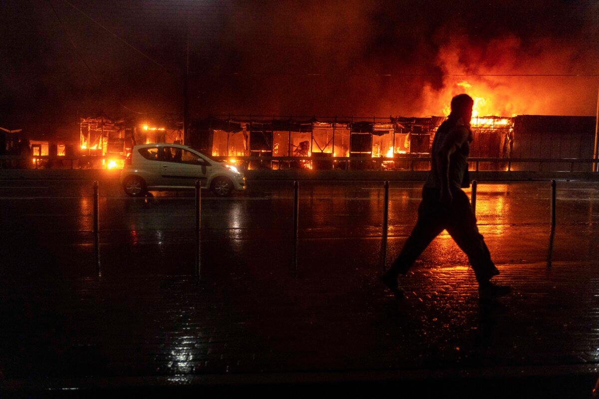 A resident walks in front of a burning market following a Russian missile strike in Kyiv, Ukraine, on June 15, 2026. (Oleksii Flilippov/AFP via Getty Images)