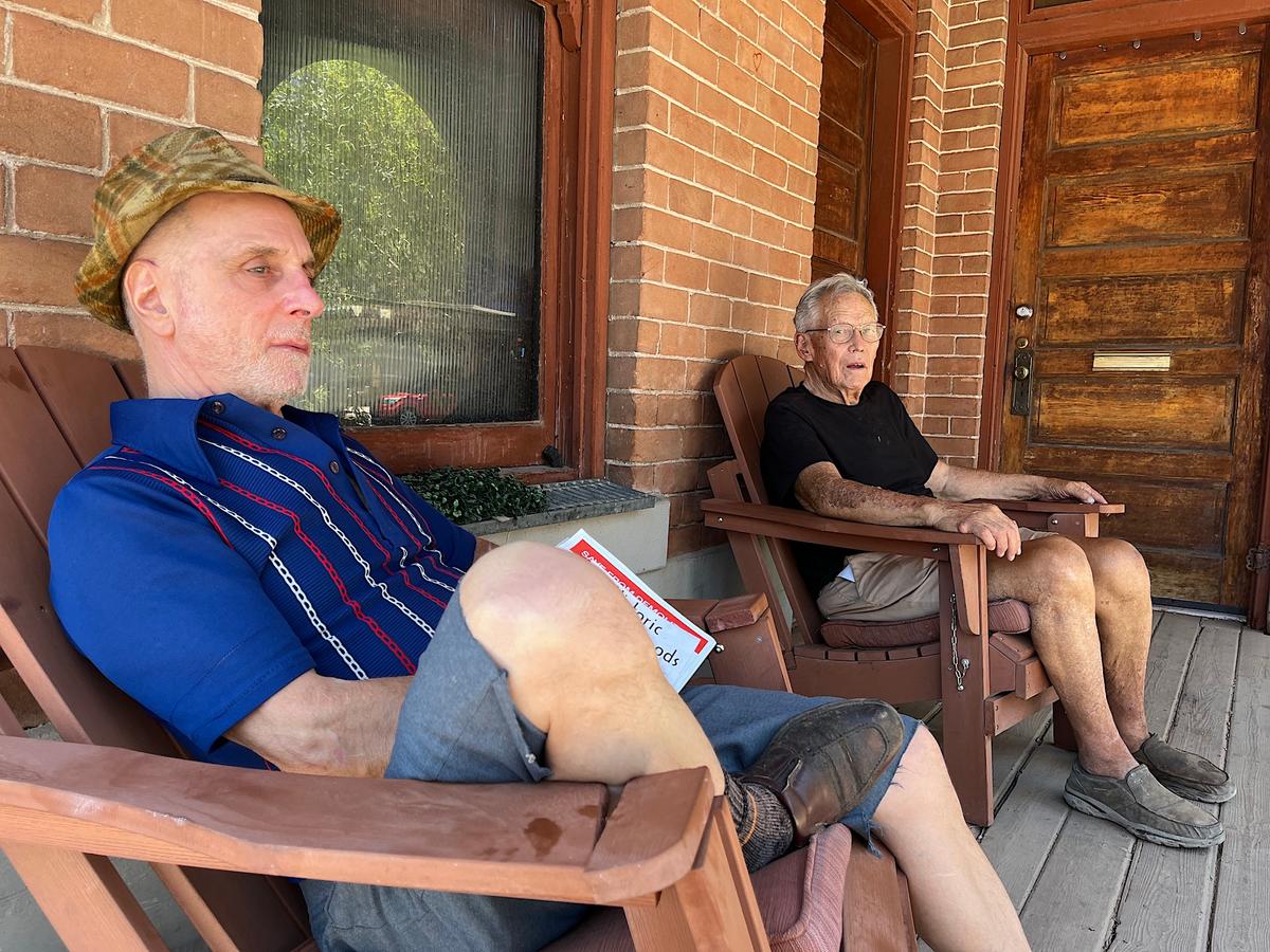 Longtime tenant Barry Schwartz (L) and owner Robert Young sit on the front porch of the historic Louis Emerson House on June 13, 2026. (Allan Stein/The Epoch Times)