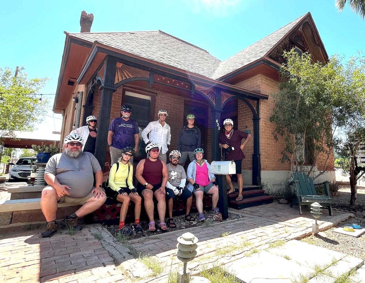 Members of the Phoenix Spokes People, a cycling group, gather in support of the property owner on the front porch of the Louis Emerson House in Phoenix on June 13, 2026. (Allan Stein/The Epoch Times)
